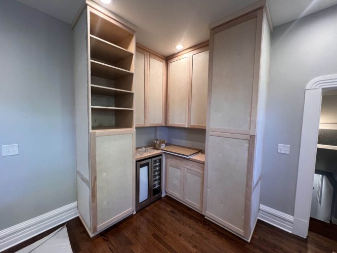 Unfinished corner kitchen cabinets feature wooden shelving - before painted by Pearl Painters