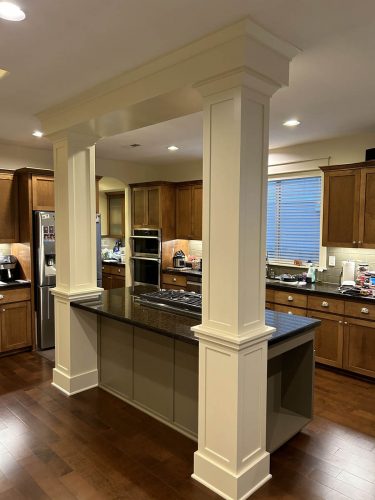 Rear view of kitchen island with large floor to ceiling columns freshly painted