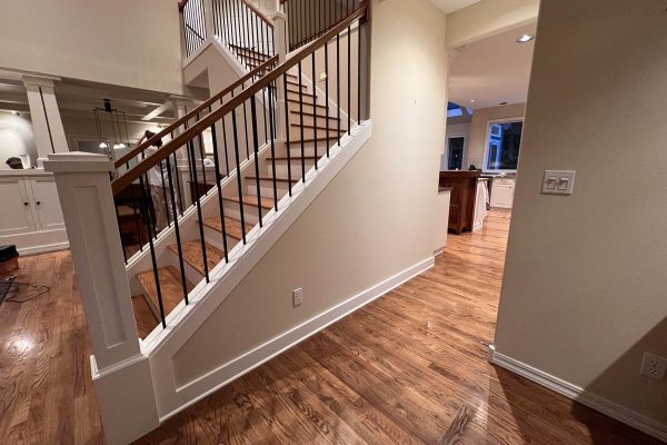 A staircase in a Wilsonville home with hardwood floors and high ceilings.
