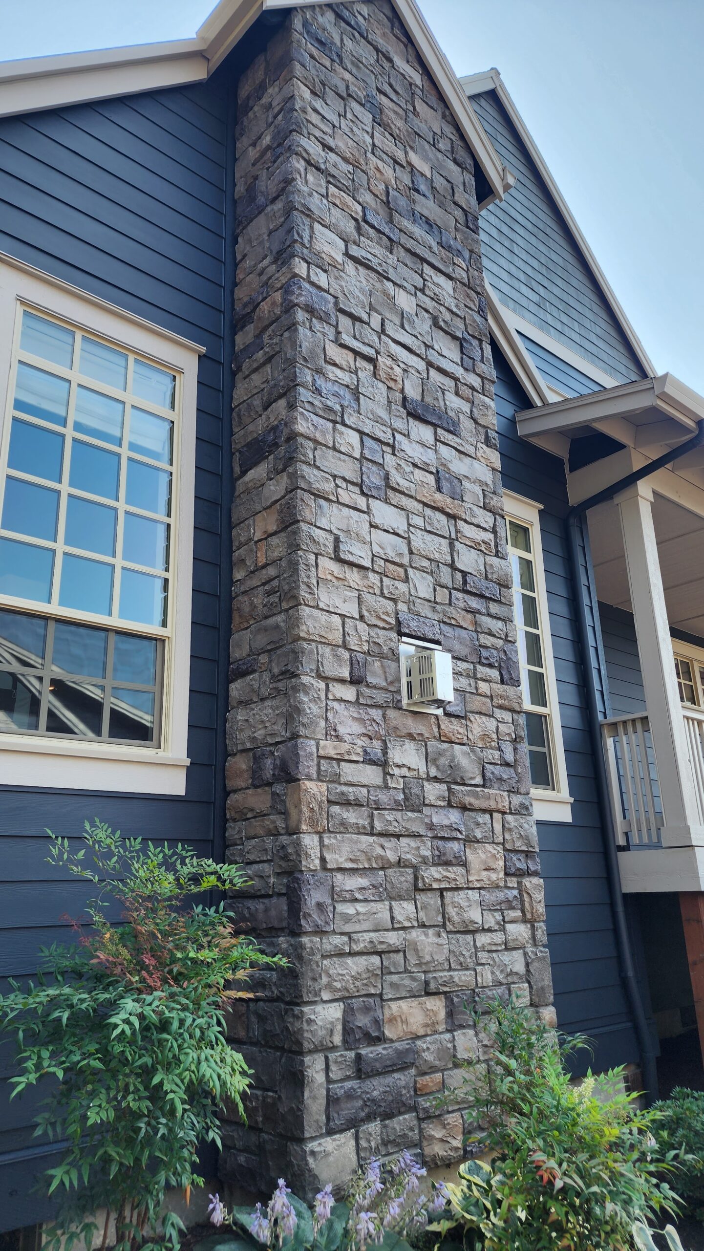 A fresh transformation of a Whitford house, featuring stunning stone siding and a classic brick chimney.