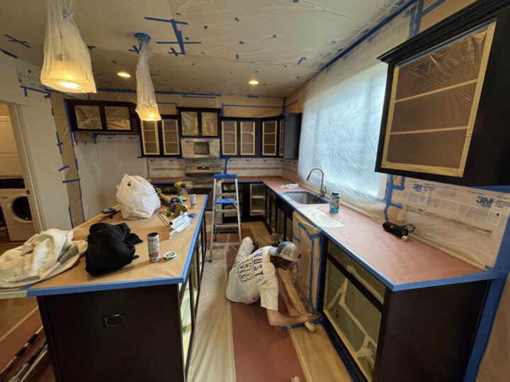 Pearl Painters team member inside kitchen working on cabinets