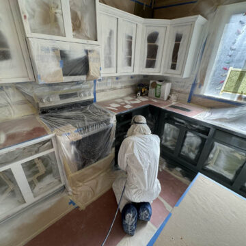 Pearl Painters team member inside kitchen working on cabinets