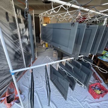 Professionally painted kitchen cabinet doors hanging in garage to dry