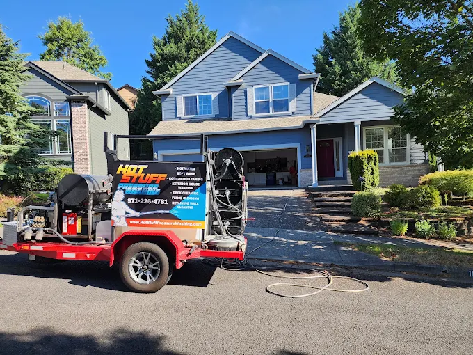 Pressure washing trailer labeled "Hot Stuff" outside a suburban house; painting prep by Pearl Painters, Portland.