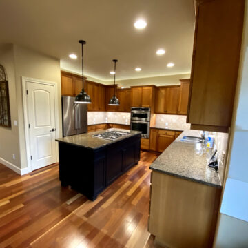 Portland kitchen prepped for interior painting by Pearl Painters; paint swatches visible on wall, modern appliances throughout.