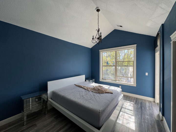 Bedroom with bed and window, freshly painted dark blue in Portland, OR