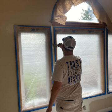 A man painting an interior window in a Beaverton home.