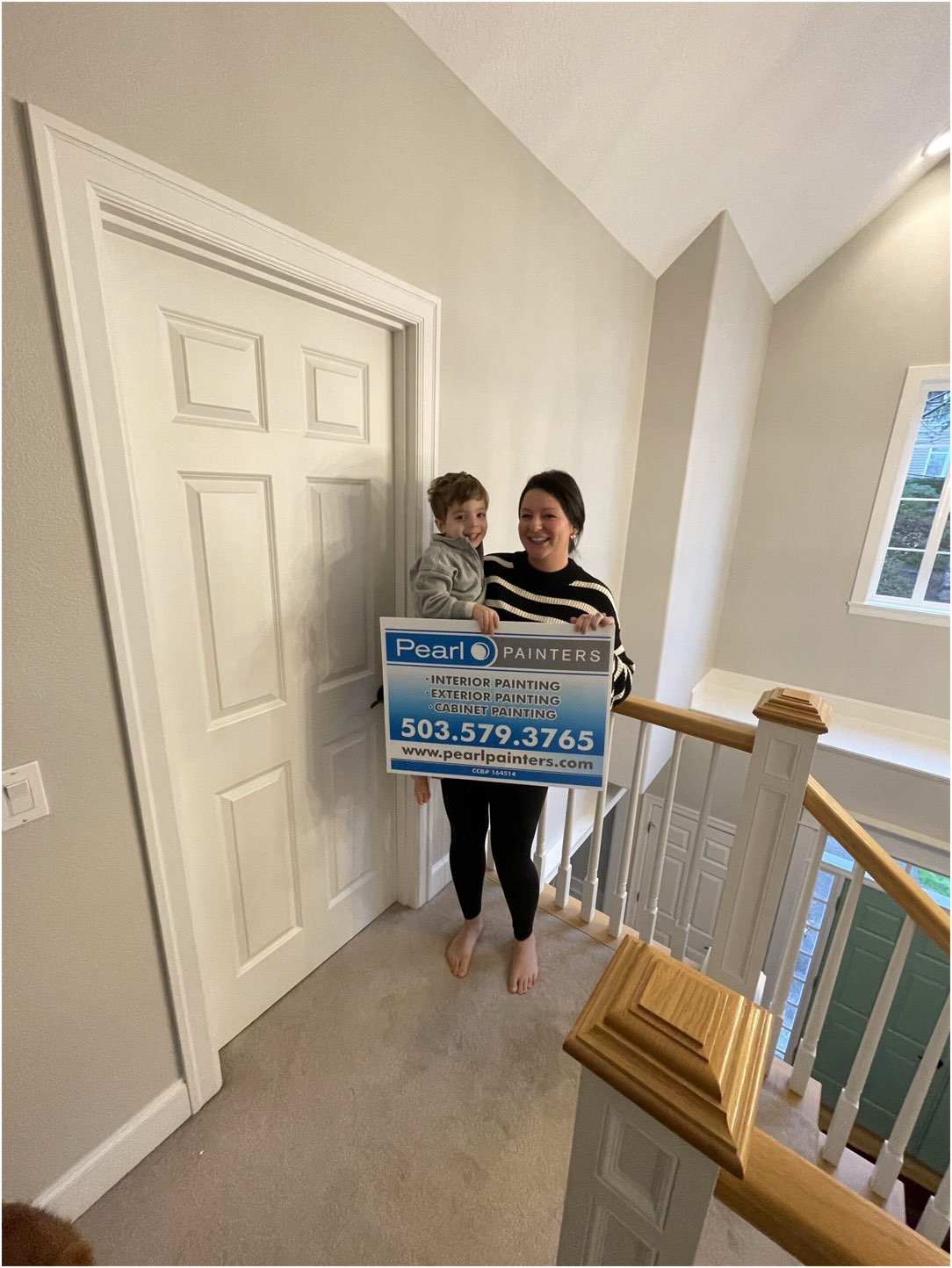 West Linn interior painted by Pearl Painters, with mom and child holding sign while smiling