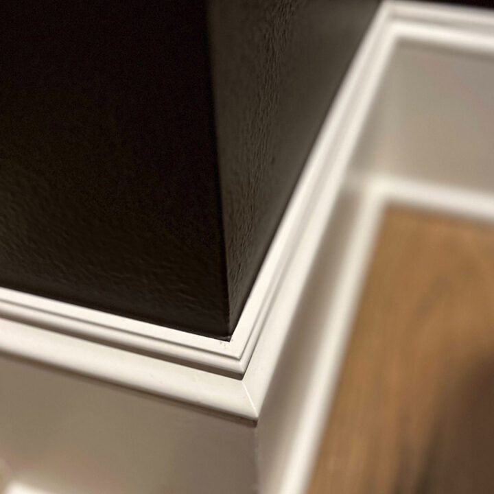 Pearl Painters' work: black wall meets white trim and baseboard, with sharp paint lines above a light wood floor in Portland