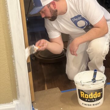 Painter painting trim inside home.