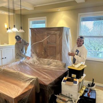 Two men are painting a room in a Wilsonville home.