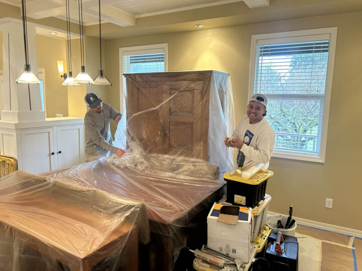 Two men are painting a room in a Wilsonville home.