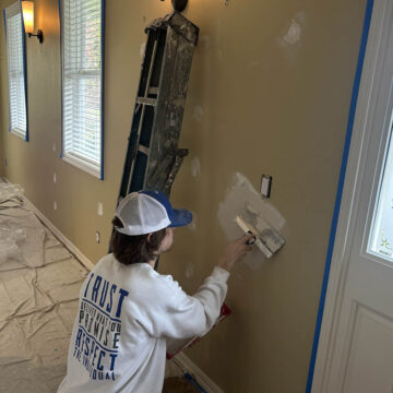 A woman painting a wall in her Wilsonville home.