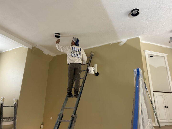 A man in Wilsonville painting the ceiling of a home.