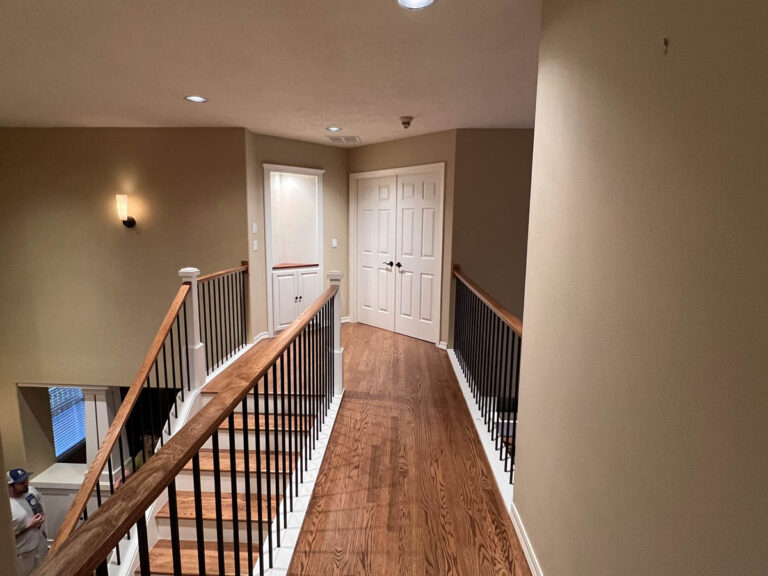 A stairway with hardwood floors and a wooden railing in a Wilsonville home.