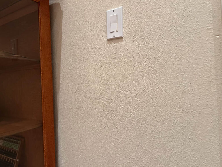 A light switch on a wall next to a cabinet in a Wilsonville home.