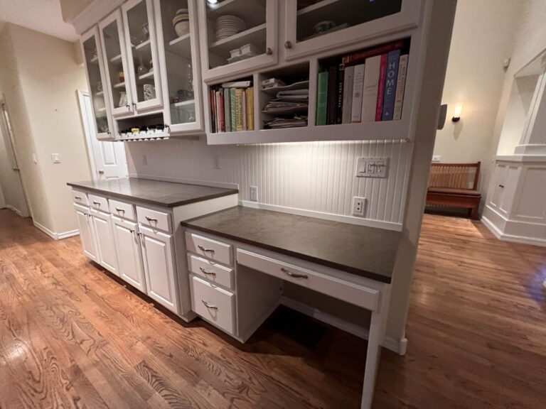 A kitchen with white cabinets and shelves in a home.