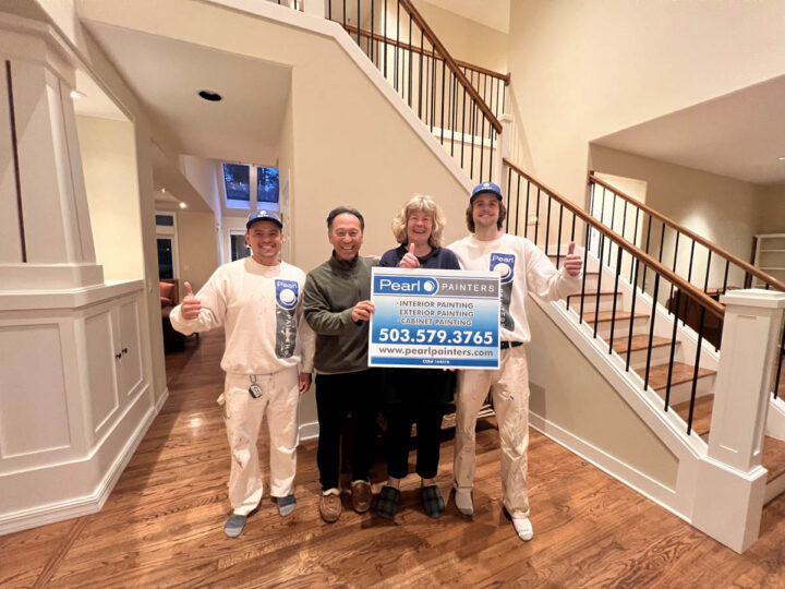 A group of people standing in a Wilsonville home hallway holding a sign.