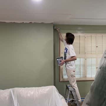 A man painting a house wall.