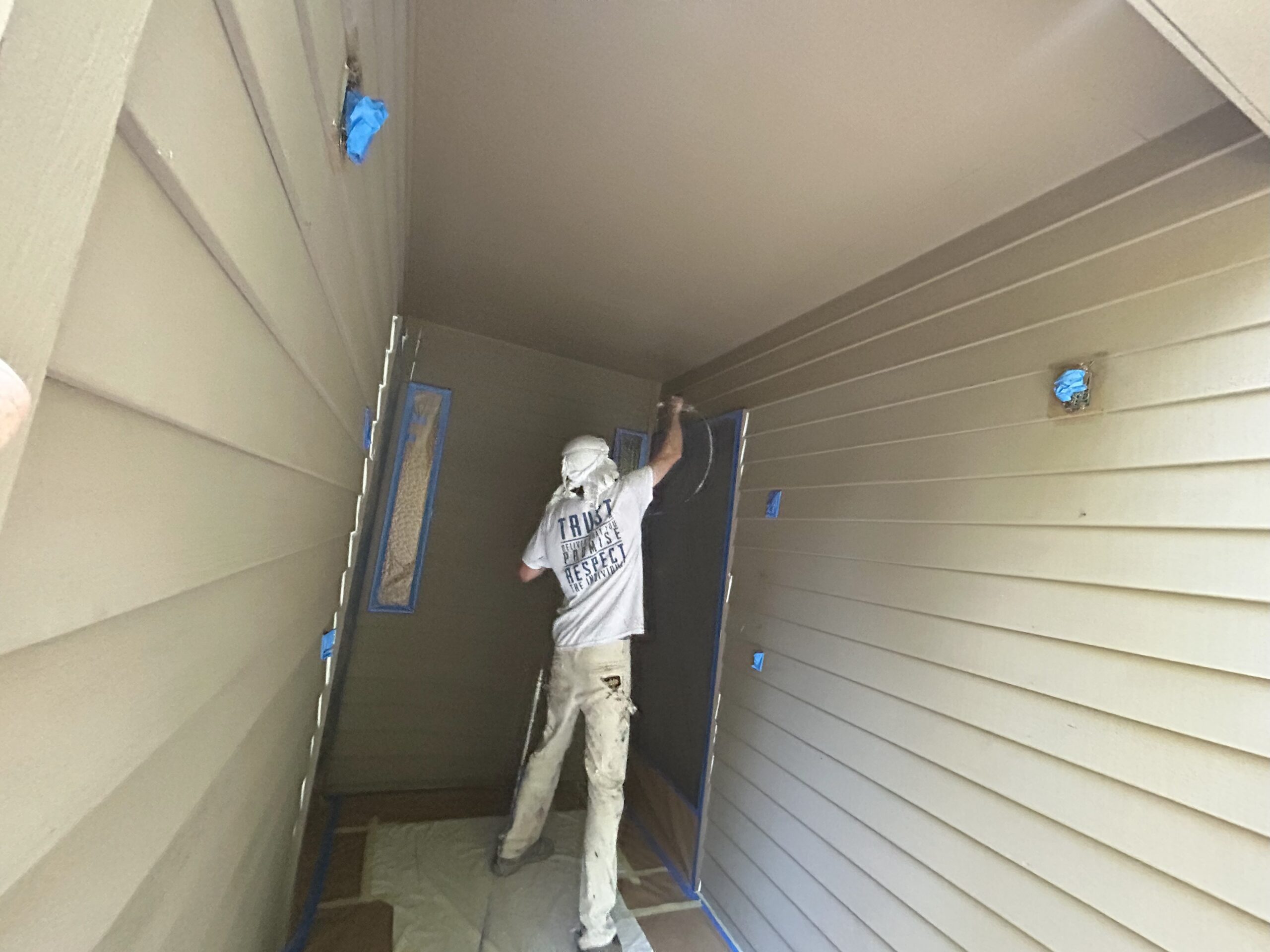 A man painting the exterior siding of a house in Portland.